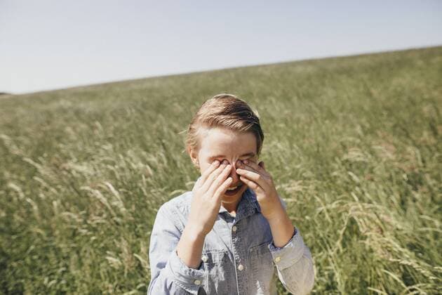 Boy on a field rubbing his eyes model released Symbolfoto  KMKF00296