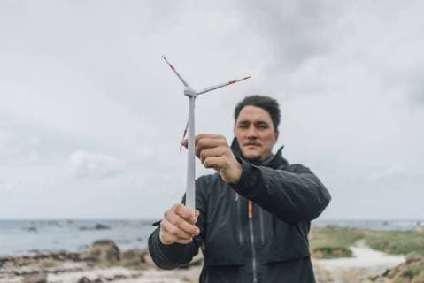 IMAGO Creative: Corporate: Klimaschutz, Digitalisierung und Urbanisierung France, Brittany, Meneham, man with miniature wind turbine at the coast model released Symbolfoto  GUSF00971