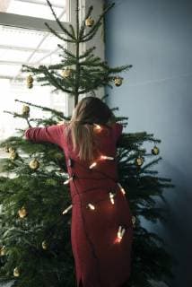 Back view of woman hugging Christmas tree model released Symbolfoto property released  MOEF01357