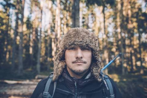Sweden, Sodermanland, portrait of young man wearing fur cap in remote landscape model released Symbolfoto  GUSF00934