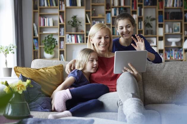 Mother and her daughters sitting on couch, having fun using digital laptop model released Symbolfoto property released  RBF06252