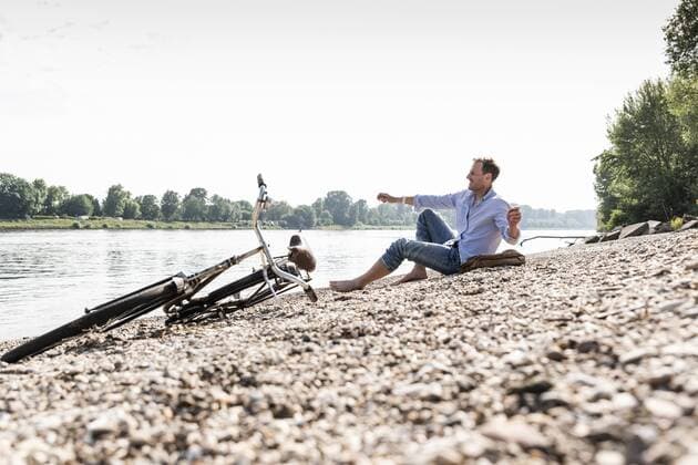 Mature man with bike at Rhine riverbank model released Symbolfoto  UUF13981