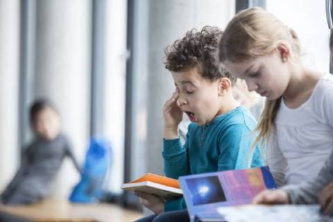 Tired schoolboy with book in school model released Symbolfoto property released  WESTF24102