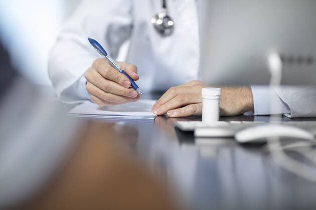 Doctor sitting at his desk taking notes model released Symbolfoto property released  ZEF15509