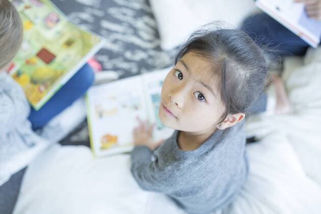 Portrait of schoolgirl sitting on the floor with book in school model released Symbolfoto property released  WESTF24164