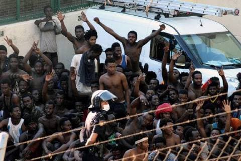 Several migrants celebrate next to a Spanish policeman in Ceuta, Spanish enclave in northern Africa, after they managed to jump the border fence between Spain and Morocco, 26 July 2018. Some 400 migrants reached Spain in a mass jump of the Spanish border early morning despite the holding operation by Spanish and Moroccan security forces. More than a dozen of Spanish Civil Guard officers and five immigrants were injured as security forces sources said that the migrants acted violently. Some 400 migrants managed to jump Spanish border fence in Ceuta !ACHTUNG: NUR REDAKTIONELLE NUTZUNG!  Copyright: xReduanx GRAF7328 20180726-636682084215644904