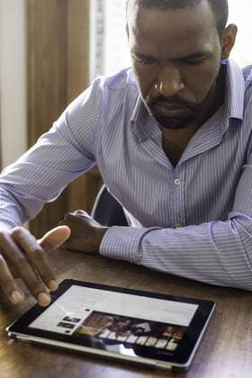 Man using digital tablet to access social media  Copyright: FrédéricxCirou B24586425