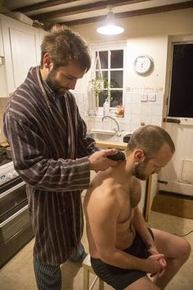 Young man shaving his brother s head home haircut in kitchen, UK - model released www.geographyphotos.com 968_19_17idm5472