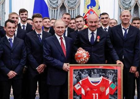 MOSCOW, RUSSIA - JULY 28, 2018: The President of Russia Vladimir Putin (3rd L front), the head coach of Russian s national team Stanislav Cherchesov (2nd R front), and Russian football players pose with a Number 11 football jersey for a photographafter a ceremony to present government awards to Russia s national men s football team and coaches at the Kremlin; the Russian national team reached the quarterfinals at the 2018 FIFA World Cup. Mikhail Metzel TASS  TS08B0AF