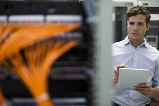 Computer technician using digital tablet performing maintenance check of mainframe equipment  Copyright: FrédéricxCirou 35778725st
