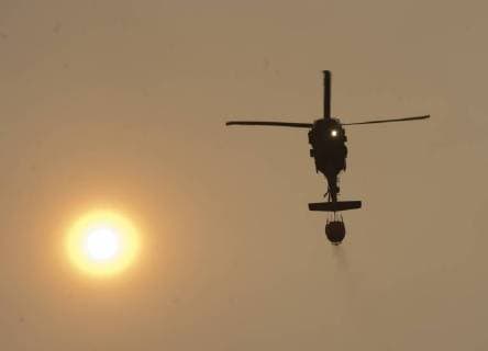 A helicopter dumps water along a ridge in Colusa County, California on August 7, 2018. The Mendocino Complex fire has become the largest in the state s history.  SXP2018080733 TERRYxSCHMITT