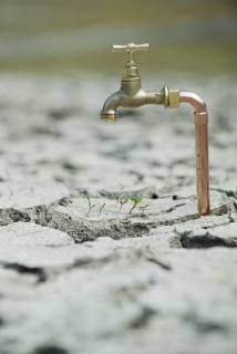 IMAGO Nature: Unsere Erde, Klimawandel, Dürren Faucet over seedlings growing in dry, cracked earth  Copyright: OdilonxDimier B02566220