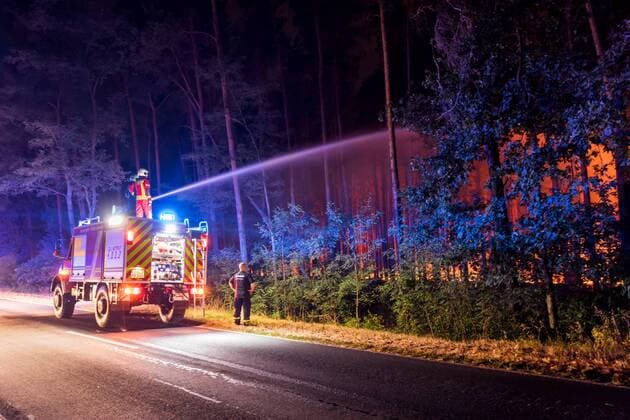 IMAGO Nature: Unsere Erde, Klimawandel, Waldbrände News Bilder des Tages 24.08.2018, Brandenburg, Deutschland, GER - Großbrand in einem Wald in Brandenburg zwischen den OrtschaftenTreuenbrietzen und Jüterborg. Am Mittag ist das Feuer nahe der Ortschaft Treuenbrietzen ausgebrochen. Bis zum Abend breitete sich der Waldbrand auf eine Fläche von ca. 300 Hektar aus. Im Bild ein Tanklöschfahrzeug dahinter der brennende Wald. . *** 24 08 2018 Brandenburg Germany GER Large fire in a forest in Brandenburg between the villages Treuenbrietzen and Jüterborg At noon the fire near the village Treuenbrietzen erupted Until the evening the forest fire spread to an area of u200b u200babout 300 hectares In the picture a tanker behind the burning forest