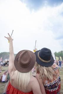 Friends cheering and holding plastic cups during music festival model released Symbolfoto  ABIF00600
