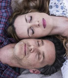 Couple with closed eyes lying down head to head model released Symbolfoto  UUF14532