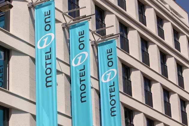 Flaggen mit Firmenlogo Motel One an der Fassade eines Neubau s in der Innenstadt Frankfurt, Hessen, Deutschland