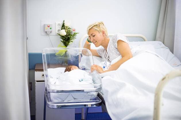 Mutter, die liebevoll ihr neugeborenes Baby noch im Krankenhaus betrachtet Copyright: imageBROKER/JacekxSopotnicki ibxjas04734533.jpg