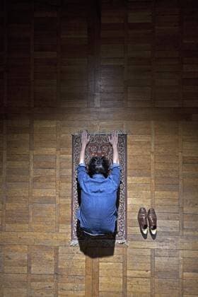 A man praying on a mat  Copyright: Halfdark fStopImages1142051