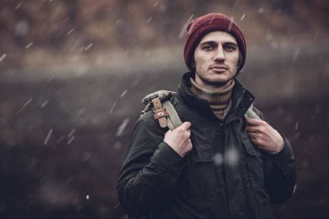 IMAGO Creative: Jahreszeit Winter, Spaziergang Portrait of man carrying backpack while standing outdoors during snowfall  Copyright: VasilyxPindyurin fStopImages1663025