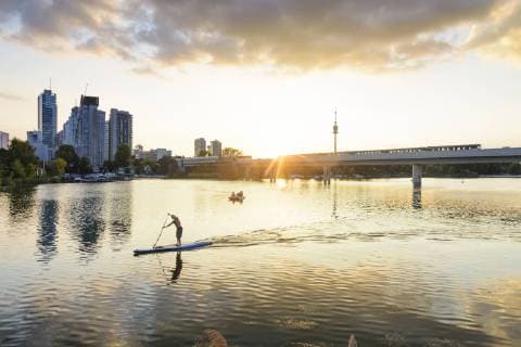 sunset at lake Alte Donau (Old Danube), skyscraper of Donaucity, Donauturm (Danube Tower), bridge of subway line 1, stand up paddler (SUP), boat Wien, Vienna Wien Austria 22. Donaucity