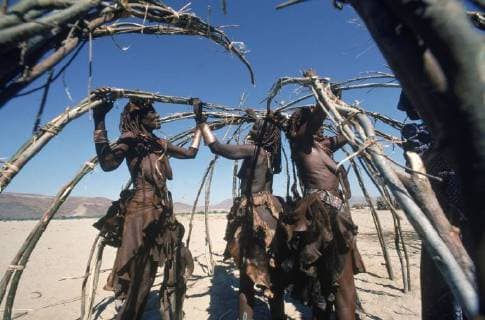 IMAGO Cultures of the world, Himba Volk in Namibia Himba women lash poles together to make a hut in their village in the desert of the Skeleton Coast of Namibia., Namibia Copyright: RobertxCaputo 0350355509