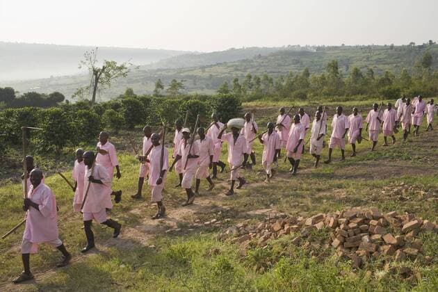 Prisoners head out into fields surrounding Nsinda Prison. Rwanda s largest prison, about 60 km. east of the capital, still holds 11,200 prisoners, primarily from the genocide. About a thousand of them go out each morning to work in nearby fields, growing what they eat., Rwamagana Province de L est Rwanda Copyright: KevinxHoran 3244300006