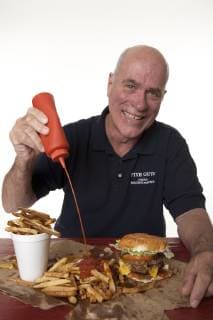 Jerry Murrell, CEO of Five Guys Famous Burgers and Fries squirts the ketchup on Five Guys fresh cut Idaho french fries., Washington D.C. USA Copyright: RandallxScott 4286700005