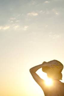 IMAGO Creative, Jahreszeit Sommer, Sonnenschutz Woman outdoors silhouetted against setting sun  Copyright: FrédéricxCirou B67486609