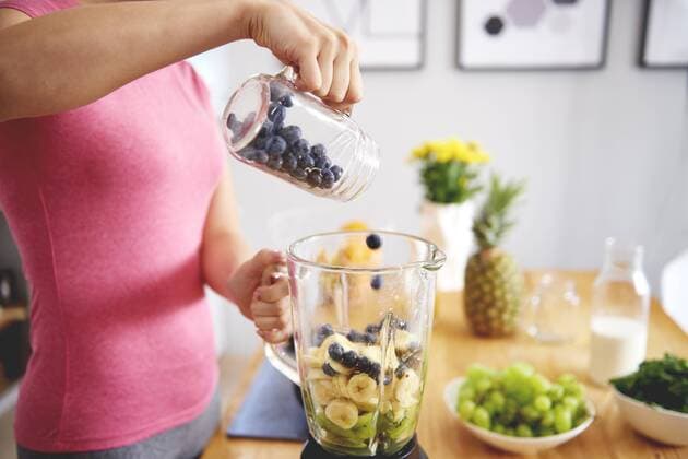Young woman preparing smoothie in the kitchen, partial view model released Symbolfoto property released  ABIF00782