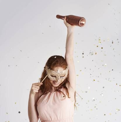 Happy young woman with bottle of champagne and masquerade mask model released Symbolfoto  ABIF00887