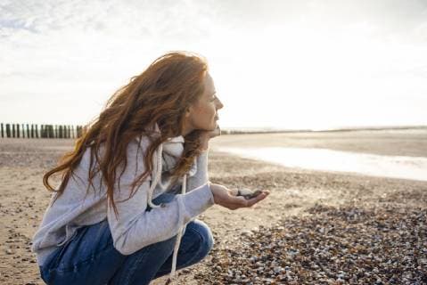 Redheaded woman collecting shell on the beach model released Symbolfoto  KNSF04273