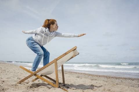 Woman standing on deck chair, pretending to surf model released Symbolfoto  KNSF04303
