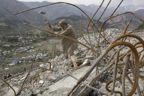 A worker uses a sledgehammer to break up concrete, as he works to clear the debris of a hotel that collapsed in the 2005 earthquake, in the devastated town of Balakot, Azad Jammu and Kashmir, Pakistan. Five months after the earthquake which destroyed ninety percent of the buildings and killed thousands in the town of Balakot, little reconstruction had begun. In April, the Pakistani authorites have decided they will not rebuild what was once the picturesque mountain town of Balakot, as it sits directly on a fault line, but will relocate it. They have banned all reconstruction on the existing site. Throughout the region of Pakistan affected by the earthquake, over 73,000 people were killed and over 3 million made homeless., Balakot Jammu and Kashmir Pakistan Copyright: BethxWald 9085600004