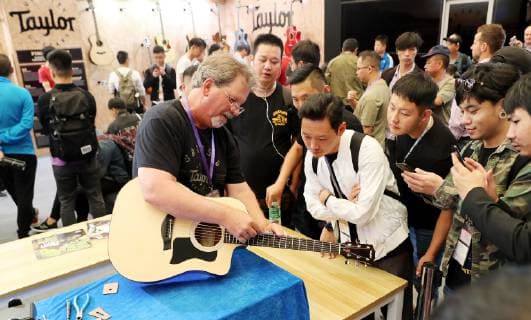 (181010) -- SHANGHAI, Oct. 10, 2018 -- A staff from a Canadian guitar producing company shares guitar knowledge with visitors during the Music China held in east China s Shanghai, Oct. 10, 2018. The 2018 Music China, a musical instrument trade show, opened on Wednesday in Shanghai. Over 2,200 musical instrument companies and dealers from 31 countries and regions participate in the show. ) (sxk) CHINA-SHANGHAI-MUSIC CHINA (CN) FangxZhe 