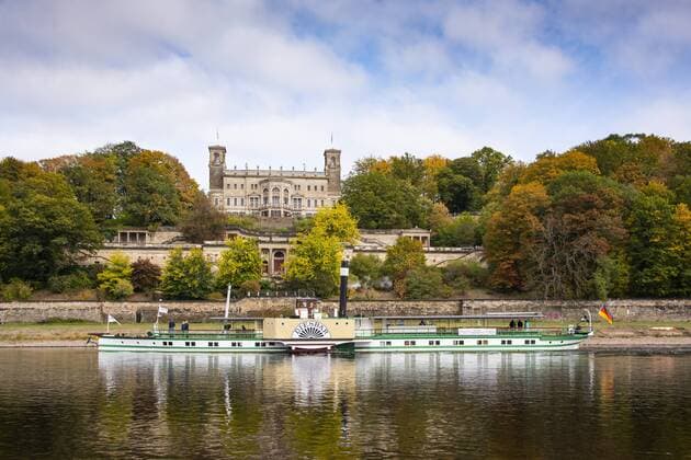 Das Schloss Albrechtsberg an der Elbe in Dresden, der Landeshauptstadt des Bundeslandes Sachsen. Im Schlosspark herbstlich gefärbte Bäume. Auf der Elbe das historische Dampfschiff Diesbar. Foto: Volker Hohlfeld Schloss Albrechtsberg an der Elbe