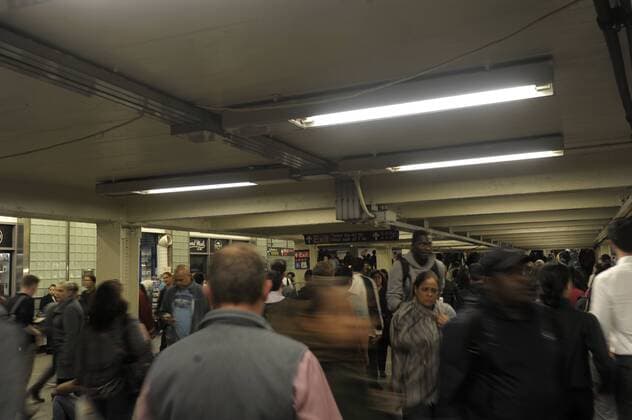 U-Bahnhof TImes Square. Fahrgästen gehen in einem Untergeschuss zu anderen Gleisen. New Yorker U-Bahn