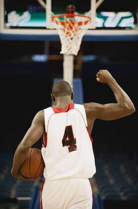 Basketball with fist raised in victory, rear view  Copyright: OdilonxDimier B30108824