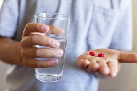 Boy holding glass of water and tablets, cropped  Copyright: AntoinexArraou B88596514