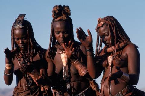 IMAGO Cultures of the world, Himba Volk in Namibia Three Himba women dance and sing at their village on the Skeleton Coast; Western Kaokoland, Namibia., Namibia Copyright: RobertxCaputo 6500503601