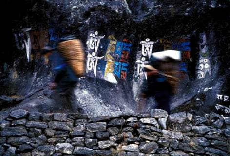 IMAGO Nature: Unsere Erde, Naturschutz, Indigene Völker Poters walk past political graffiti in Phakding, Khumbu region (on the way to Everest), Nepal, Copyright: ScottxWarren 6698100039