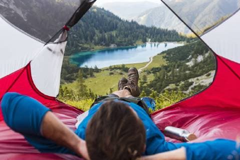 Austria, Tyrol, Hiker relaxing in his tent in the mountains at Lake Seebensee model released Symbolfoto  DIGF04785