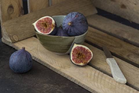Sliced and whole fresh figs, kitchen knife and wooden box  JUNF01224