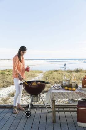 A woman grilling on the beach in Florida, Grayton Beach FL USA model released Symbolfoto Copyright: StephenxDeVries DETE000006