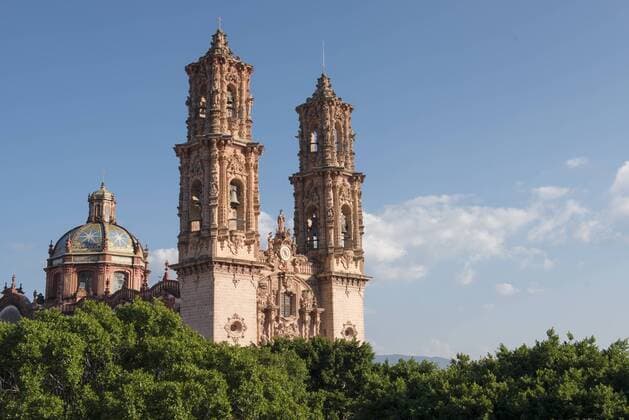 The itricate decorations of Taxco Cathedral s tower stand proud over the treeline, against a blue sky., Taxco Guerrero Mexico Copyright: MarcosxFerro FEMR000829
