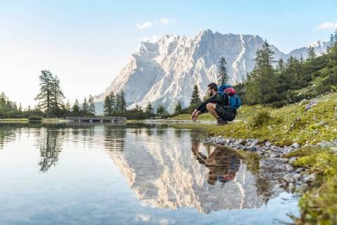 Austria, Tyrol, Hiker taking a break, crouching by the lake model released Symbolfoto  DIGF04795