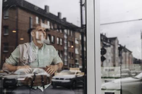 Young business owner sitting in his coffee shop, daydreaming model released Symbolfoto property released  GUSF01283