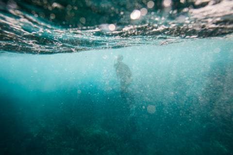 IMAGO Creative: Kraft des Wassers The outline of a snorkeler is seen through bubbles and turbulent currents underwater as waves break onto rocks and reef off Utila Island, Honduras., Utila Roataon Honduras Copyright: LoganxMock-Bunting MOLO000298