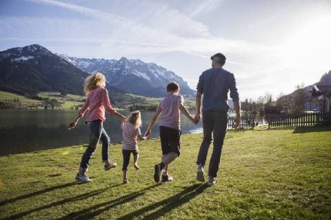 Austria, Tyrol, Walchsee, happy family walking at the lakeside model released Symbolfoto  JLOF00201