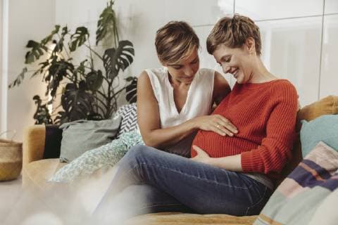 Happy lesbian couple touching belly of the expectant mother model released Symbolfoto property released  MFF04442