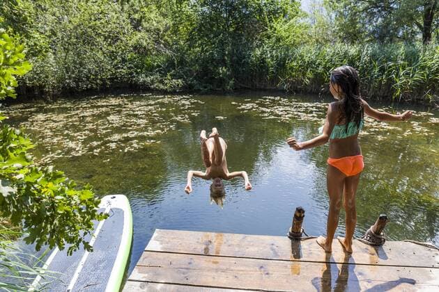 Girl watching her friend jumping into pond model released Symbolfoto property released  TCF05731